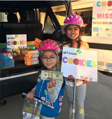 two girls with girl scout cookies